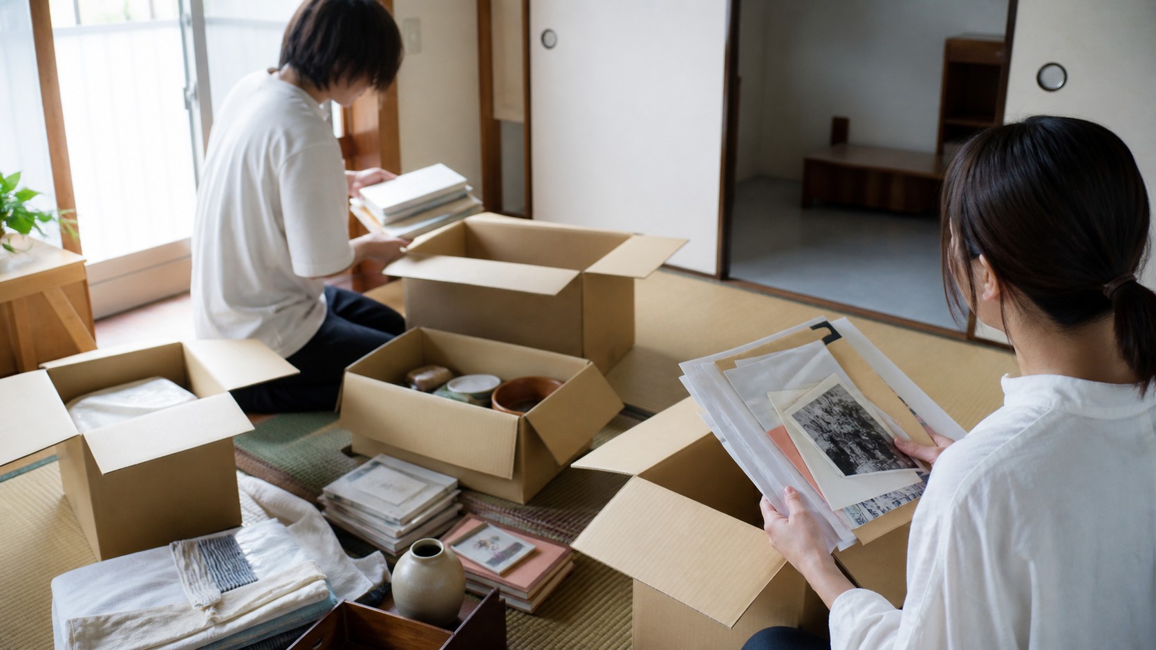 実家の畳の部屋で書類や思い出の品を丁寧に仕分けする様子